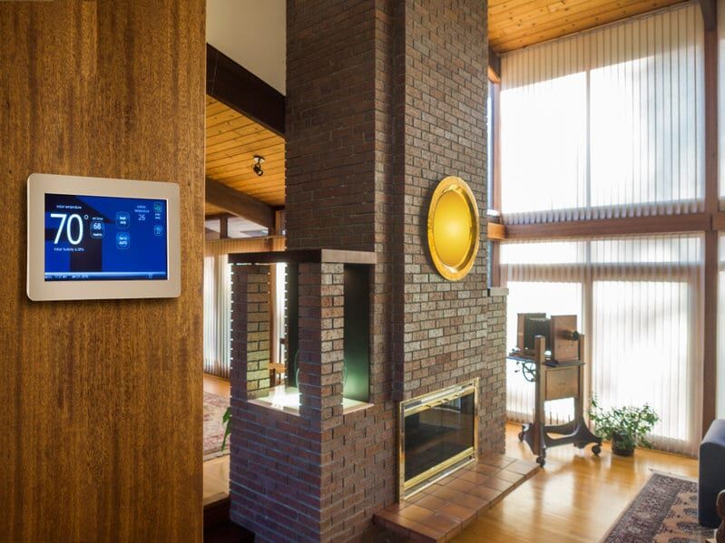 3 Benefits of a Zoned HVAC for Your Home 1 Smart thermostat on wall in modern living room.