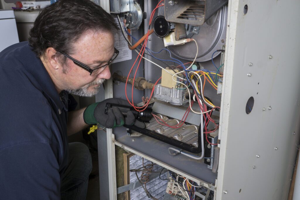 A technician servicing a furnace